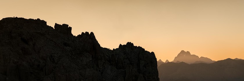 Trois chamois courent sur les crêtes au lever de soleil.